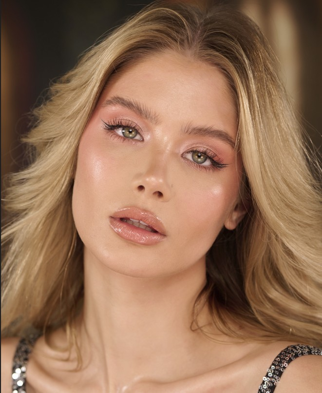 A model showcasing the Kisses & Lashes Peach Lust set, including a beautiful gold shimmer lip gloss and luxury synthetic lashes perfect for the Christmas season