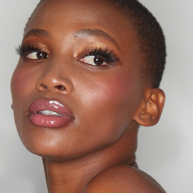Portrait of a model showcasing the radiant finish of an eyeshadow from the SOSU x Bonnie Ryan Palette, complemented with glossy lips and highlighted cheeks.