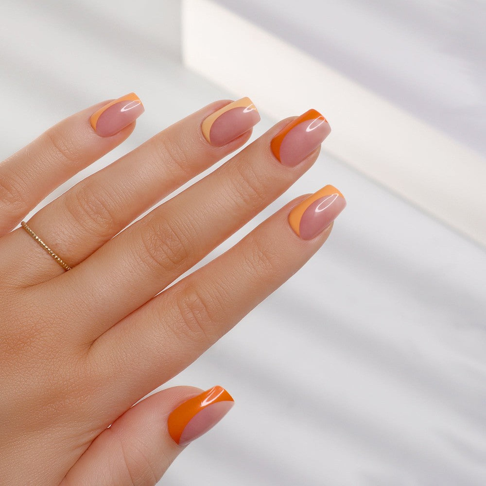 Soft orange tone Mocktail nails with an extreme gloss finish, perfect for a summer sunset, showcased on a hand
