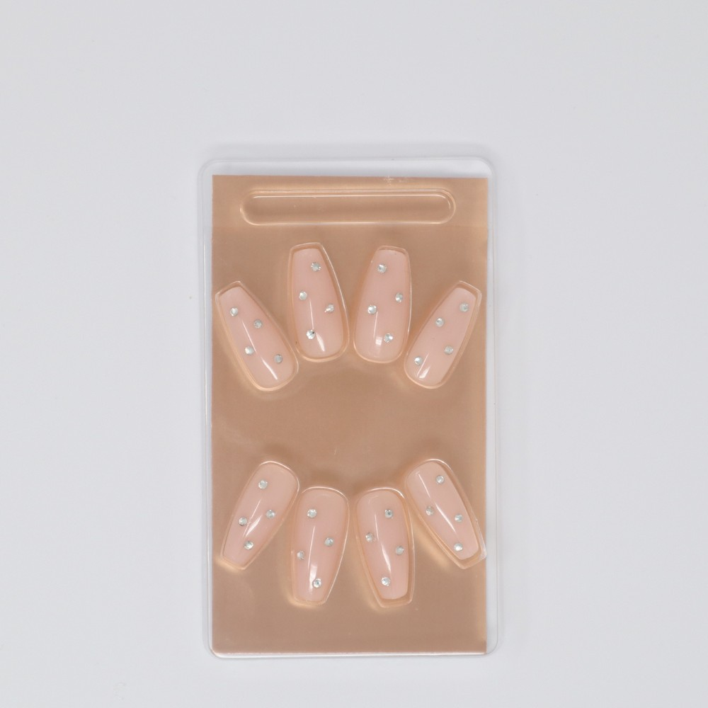 A set of Shine Bright press-on nails from SOSU in a classic nude color with trendy jewel accents, showcasing an extreme gloss finish and including adhesive, mini nail file & manicure stick for easy application & removal