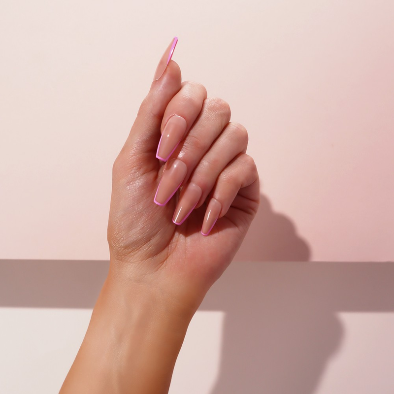 A hand showcasing the stunning Pink Party Faux Nails in a ballerina shape and medium length, promising easy application and removal with an extreme gloss finish.